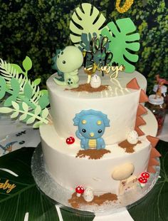 a three tiered cake decorated with plants and animals