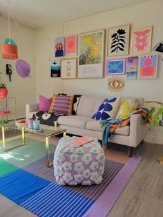 a living room filled with lots of furniture and pictures on the wall above it's coffee table