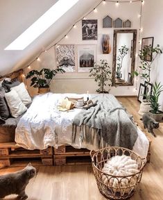 an attic bedroom with white walls and wooden flooring is furnished with natural materials such as wood pallets