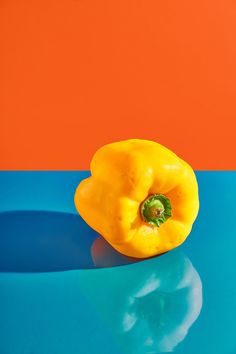 a yellow pepper sitting on top of a blue table