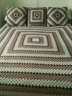 a crocheted bedspread with brown and white squares