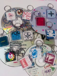 several key chains with different designs and words on them, all in various shapes and sizes