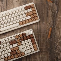 two keyboards with brown and white keys on a wooden table