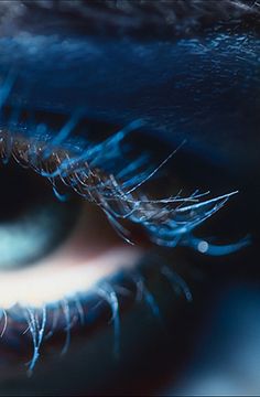 an extreme close up shot of the iris of a person's eye with blue and black colors