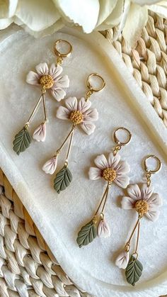 four flower charms sitting on top of a white tray