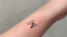 a small tattoo on the arm of a woman's left arm with a butterfly