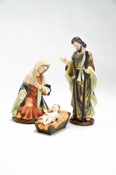 two nativity figurines, one holding a baby jesus