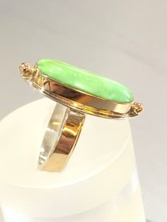 "This Marquise Style Carico Lake Faustite Green Turquoise ring was fabricated in my studio using 14k gold and sterling silver. This Carico Lake Turquoise Faustite cabochon is worthy to be set in gold. The cabochon is set with a 1/8\" tall 14k bezel. The top and bottom beads are also solid 14k gold. They are soldered on a 24 gauge sterling silver plate. The sterling silver 12 gauge rectangle ring band is adorned with a wonderful mirror finished 1/8\" wide 30 gauge strip of 14k Gold. The Ring is a Rectangle Ring, Silversmith Jewellery, Sterling Silver Rings Bands, Royston Turquoise, 12 Gauge, Cabochons Stones, Blue Gems, Coral Turquoise, Green Turquoise