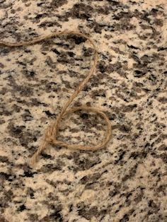 a heart - shaped rope is tied to a granite surface