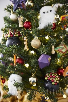 a christmas tree decorated with ornaments and other holiday decorations, including an owl ornament