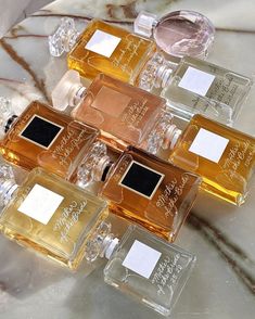 five different perfume bottles sitting on top of a marble counter