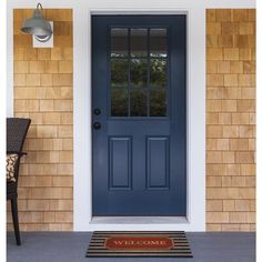 a blue front door on a brick house with a chair and lamp in the foreground