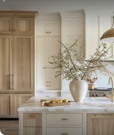 a vase with flowers in it sitting on a kitchen counter top next to an oven