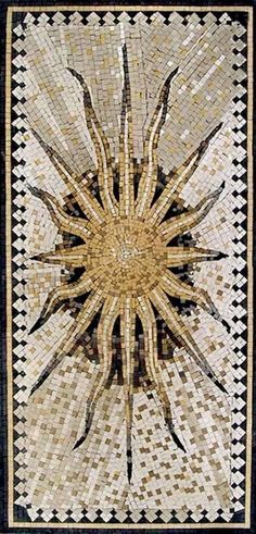 an intricately designed wall hanging in the shape of a sun with black and white squares