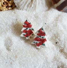 two small christmas trees are sitting on some snow