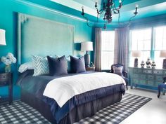 a bedroom decorated in blue and white with a chandelier