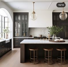 a large kitchen with black cabinets and marble counter tops is featured in the magazine's march issue