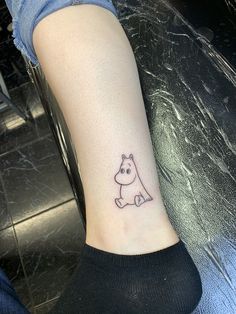 a person with a small tattoo on their ankle that has a dog sitting on it