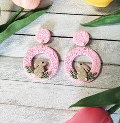 a pair of pink earrings with an image of a koala on the front and back