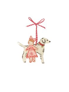 a christmas ornament with a girl and dog hanging from it's side