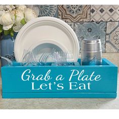 there is a blue tray with plates and cups in it that says grab a plate let's eat