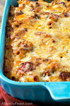 a blue casserole dish filled with cheese and meat