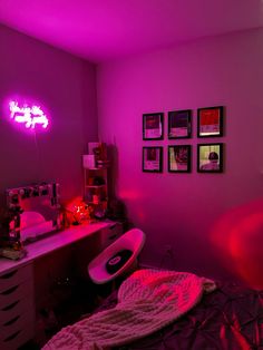 a bedroom with pink lighting and pictures on the wall