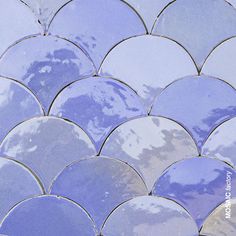 a close up view of a blue and white mosaic tile pattern with clouds in the background