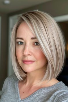 a woman with blonde hair is looking at the camera while she's wearing a gray shirt