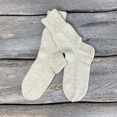 two pairs of white socks sitting on top of a wooden table