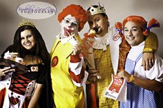 three people dressed in costumes posing for a photo with one person wearing a clown costume