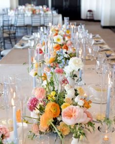 a long table is set with flowers and candles