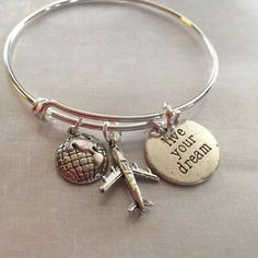 Travel bracelet. Bracelet with airplane world and stamped live your dream- Alex and Ani inspired. Bracelet is silver plated over brass. Bracelet can Inspirational Silver Stainless Steel Bracelets, Adjustable Engraved Stainless Steel Charm Bracelet, Engraved Adjustable Stainless Steel Charm Bracelet, Engraved Stainless Steel Adjustable Charm Bracelet, Silver Metal Jewelry For Travel, Travel Silver Stainless Steel Jewelry, Personalized Adjustable Jewelry For Travel, Adjustable Sterling Silver Hand Stamped Charm Bracelet, Adjustable Hand Stamped Silver Charm Bracelet