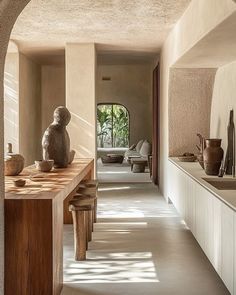 a long hallway with vases and sculptures on the counter