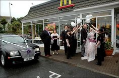 a group of people standing in front of a mcdonalds