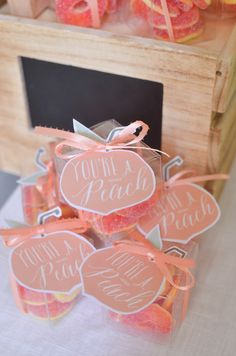 some pink candies are sitting on a table next to oranges and paper tags