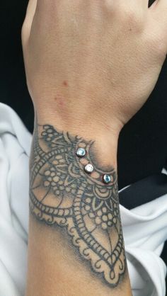 a woman's arm with a tattoo on it and a ring in the middle