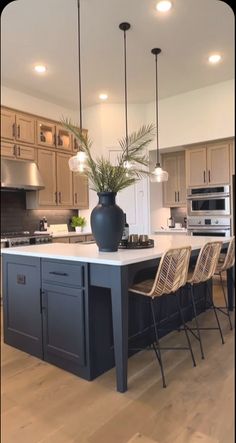 a large kitchen with an island in the middle and two chairs at the counter top