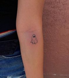 a small ghost tattoo on the arm