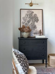 a black dresser sitting next to a bed in a bedroom