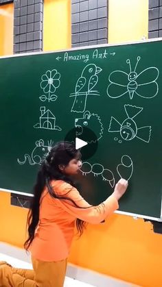 a woman writing on a blackboard with white chalk