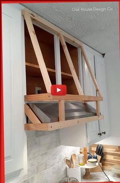 a kitchen with white cabinets and wooden shelves