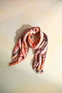 a pink and white scarf laying on top of a table