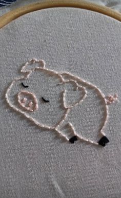 a close up of a embroidery on a piece of cloth with an animal drawn on it