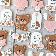 decorated cookies with teddy bears and angel wings for baby shower favors on a wooden table