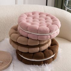 a stack of pillows sitting on top of a white chair next to a round object