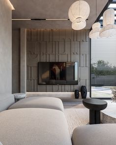 a living room filled with furniture and a flat screen tv mounted on the wall above it