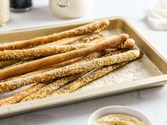 bread sticks with sesame seeds on a baking tray