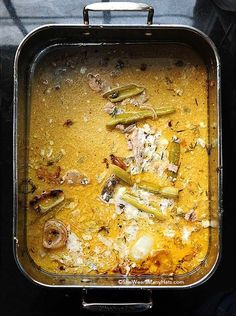 a pan filled with food sitting on top of a stove next to an oven door