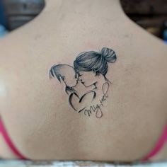 a woman with a tattoo on her back is holding a small child's head